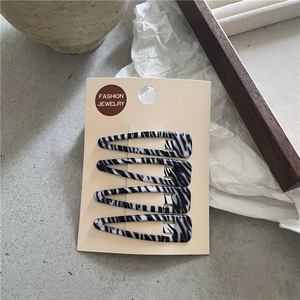 Détail d'un ensemble de quatre barrettes goutte d'eau aux motifs marbrés noir et blanc