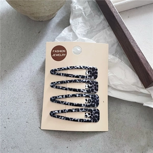 Détail d'un lot de 4 barrettes BB à motif léopard présentées sur une carte de bijoux