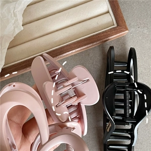 Close-up of matte pink and black hollow heart hair claws with durable metal springs