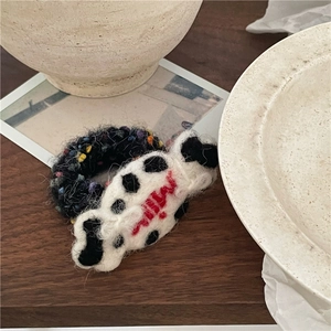 Close-up of wool felt candy hair bands featuring MILK embroidery and colorful knit texture