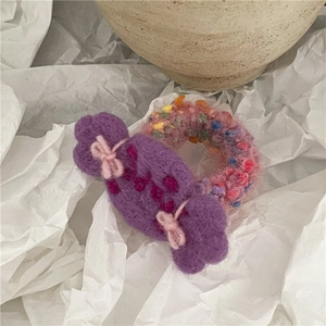 Detail of sweet wool felt candy hair tie with colorful yarn texture and embroidery