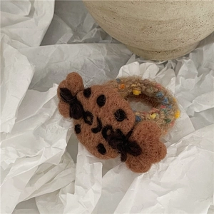 Detail of wool felt brown polka dot bow and textured boucle hair tie elastic band