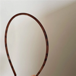 Close-up of matte leopard print headband showing non-slip teeth and resin texture