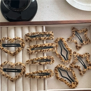 Macro shot of plush leopard print hair clips in heart and star shapes in jewelry box