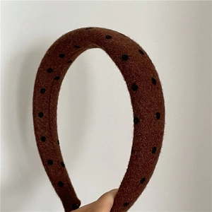 Detail showing high-quality brown wool fabric headband with black polka dot pattern textures