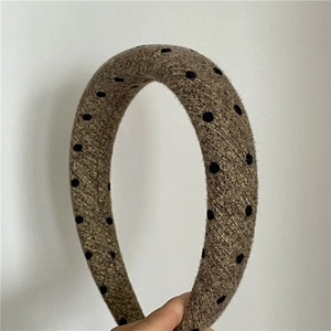 Close-up of thick dark brown tweed headband with black polka dots and soft texture