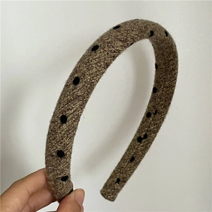 Close-up of brown woven fabric headband with black polka dots for autumn winter fashion