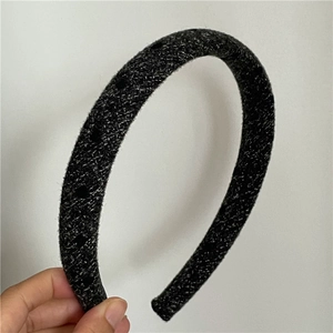Detail view of the thick dark grey tweed fabric headband with rich fiber texture