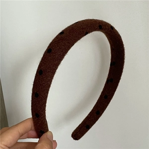 Detailed close-up showing the textured wool fabric and black polka dots on the headband