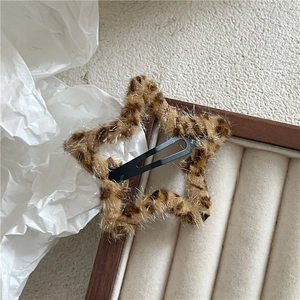 Close-up of star-shaped plush leopard print hair clip with subtle silver glitter threads