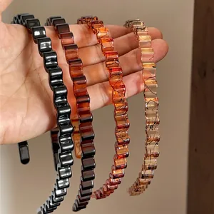Minimalist wavy resin hair bands in black, brown, and amber colors for women