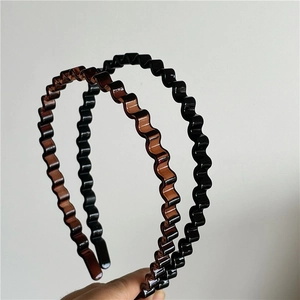 Detail showing wave-shaped plastic headbands in glossy black and amber tortoiseshell color