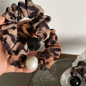 Chouchous rétro à motif léopard avec grandes perles pour une coiffure élégante et tendance