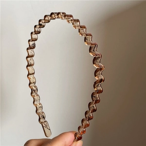 Detail of amber wavy non-slip plastic headband with a translucent resin texture