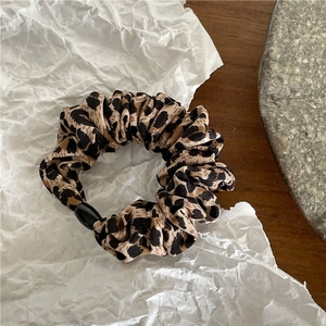 Gros plan d'un chouchou imprimé léopard avec perle noire élégante sur papier blanc