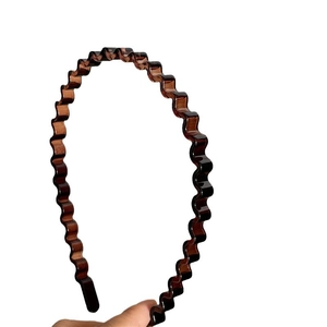Minimalist wavy plastic headband in amber brown resin finish with non-slip tooth design