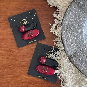 Sweet red cherry hair clips set on display card with black polka dot design