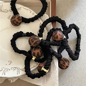 Matte leopard print ball hair tie with black pleated elastic band and golden ring