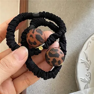 Matte leopard print beaded hair ties with black elastic bands and gold hardware