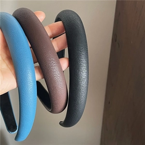 Close-up of thick padded PU leather headbands with lychee texture in blue, brown, and black