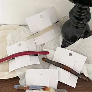 Curved acetate hair clips in tortoiseshell and marble patterns with spring barrette