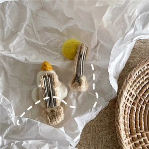 Nahaufnahme von handgefertigten Wollfilz-Enten-Haarspangen und gelben Bommel-Accessoires