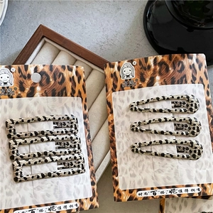 Détail de barrettes à imprimé léopard en acétate de formes rectangulaire et goutte