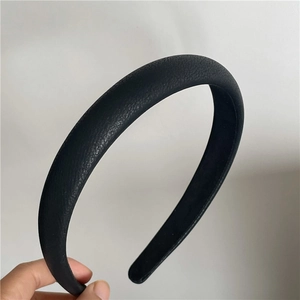 Close-up of black litchi texture PU leather headband with thick padded design