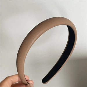 Detailed macro view of tan lychee-textured faux leather headband with non-slip lining