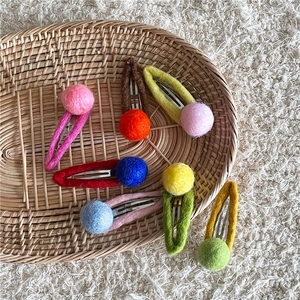 Handmade wool felt colorful ball hair clips set in a cream-colored aesthetic tray