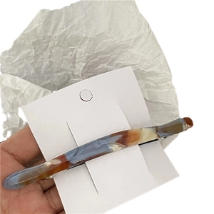 Minimalist marble pattern hair clip with blue and orange acetate texture on card