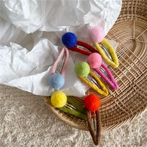 Detailed view of colorful wool felt ball hair clips set with soft handcrafted texture