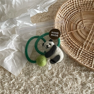 Handgefertigter Haargummi aus Wollfilz mit Panda und grünem Bommel in Verpackung