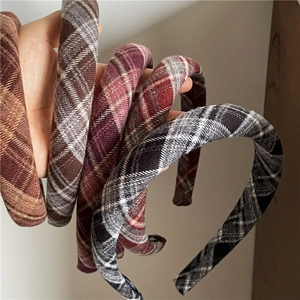 Close-up of assorted plaid padded headbands in brown, red, and grey textured fabric