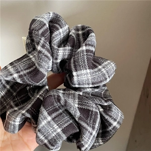 Close-up of retro black and white checkered scrunchie showing fabric texture and elasticity
