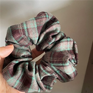 Macro shot of large pleated scrunchie with classic green and purple plaid fabric texture