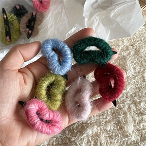 Gros plan de barrettes cœurs en laine colorée montrant la texture douce et les couleurs