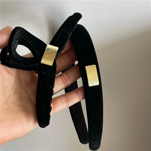 Detailaufnahme von Haarreif und Haarklammer aus schwarzem Samt mit goldener Schnalle