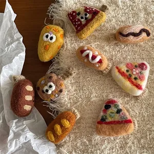 Handgefertigte Wollfilz-Haarspangen in Pizza- und Brotform auf weichem Fleece