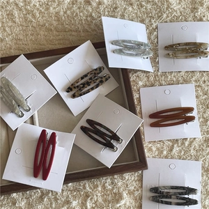 Détails de diverses pinces à cheveux ovales en acétate avec motifs marbre et ambre