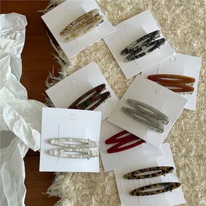 Barrettes à cheveux ovales en acétate aux motifs marbrés et léopard sur carte présentoir