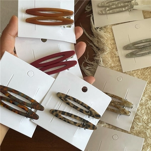 Détail de barrettes en acétate écaille de tortue avec design ovale creux sur carte