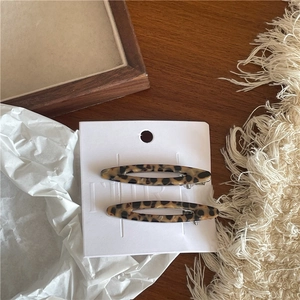 Vue détaillée de deux barrettes ovales évidées en acétate avec motif écaille de tortue