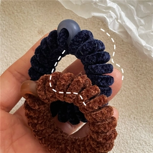Détail d'élastiques à cheveux spirale en peluche chenille bleu foncé et marron