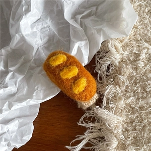 Nahaufnahme der handgefertigten Wollfilz-Baguette-Haarspange mit weicher Textur