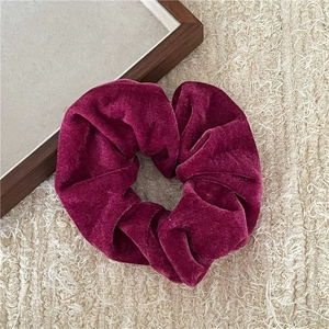 Detailansicht eines rosaroten Samt-Haargummis mit weicher Textur und elastischem Design