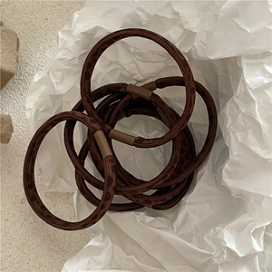 Close-up of leopard print elastic hair ties with matte brown plastic connectors