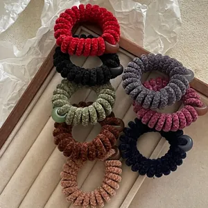 Lot de 7 chouchous en peluche style fil de téléphone aux tons terreux sur plateau velours