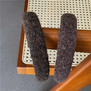 Gros plan sur la texture laineuse marron foncé et les fibres douces du serre-tête