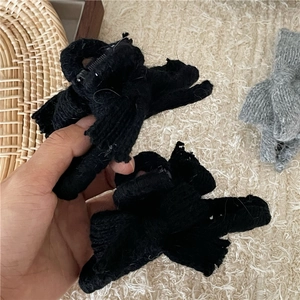 Detailed close-up showing the knitted texture of the black and gray bow hair clips
